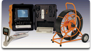 A pipe inspection camera system with a monitor, control unit, keyboard, accessories case, and an orange cable reel on wheels. The equipment is arranged on a gradient background.